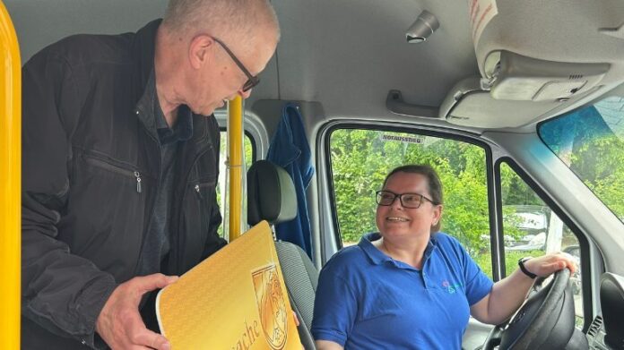Bürgerbus EAK Fahrerin Nadine Bergmann (r.) begrüßt Bürger Bodo Matzke (l.) - und die Ehrenamtskarte. Foto: Kreisstadt Mettmann