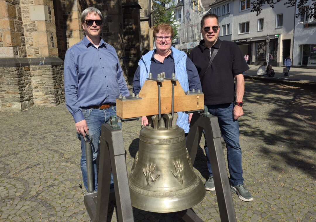 Ulrich Schulze Ueding, Andrea Töpfer und Martin Mathony mit der Chorweiler Friedensglocke vor St.Peter und Paul, Bild: Alexander Heinz