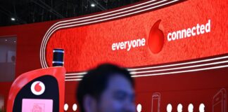 Vodafone scheut harten Preiskampf und verliert Kunden Der hat gut lachen: Ein Besucher der Mobilfunk-Messe MWC in Barcelona geht im März am Vodafone-Messestand vorbei, an dem ein überdimensionales Retro-Handy als Attrappe aufgebaut ist.