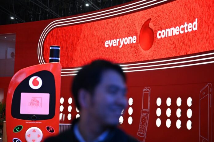 Vodafone-Messestand bei der Mobilfunk-Messe MWC Der hat gut lachen: Ein Besucher der Mobilfunk-Messe MWC in Barcelona geht im März am Vodafone-Messestand vorbei, an dem ein überdimensionales Retro-Handy als Attrappe aufgebaut ist.