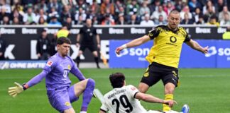 Dank Tabakovic: Gladbach feiert vorzeitigen Klassenverbleib BVB-Torwart Gregor Kobel (l) und Waldemat Anton (r) im Duell mit Gladbachs Joe Scally.