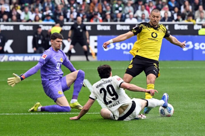 Borussia Mönchengladbach - Borussia Dortmund BVB-Torwart Gregor Kobel (l) und Waldemat Anton (r) im Duell mit Gladbachs Joe Scally.