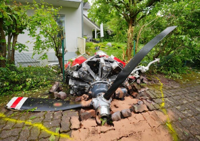 Absturz eines Kleinflugzeuges in ein Wohngebiet Ein Propeller der Maschine liegt vor einem Wohnhaus.