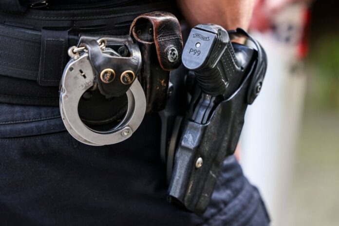 Polizist mit Waffe Gegen den 35-Jährigen lag ein offener Haftbefehl vor. (Symbolbild)