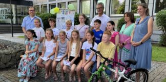 Kinder malen Bilder gegen Elterntaxis Die jungen Gewinnerinnen und Gewinner des Kreativwettbewerbs mit dem Vorsitzenden der Kreisverkehrswacht, Sascha Becker, dem Verkehrsdezernenten des Kreises, Nils Hahnheide, sowie Tanja Smigoc von der Verkehrswacht und der Leiterin des Straßenverkehrsamtes des Kreises, Uta Heber-Wenzel. Foto: Kreis Mettmann