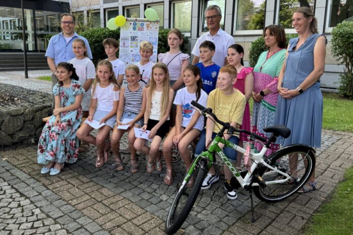 20260623-gruppenfoto-siegerehrung-malwettbewerb Die jungen Gewinnerinnen und Gewinner des Kreativwettbewerbs mit dem Vorsitzenden der Kreisverkehrswacht, Sascha Becker, dem Verkehrsdezernenten des Kreises, Nils Hahnheide, sowie Tanja Smigoc von der Verkehrswacht und der Leiterin des Straßenverkehrsamtes des Kreises, Uta Heber-Wenzel. Foto: Kreis Mettmann
