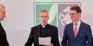 Neuer Bischof legt Eid ab – Amtseinführung am Sonntag Heiner Wilmer (Mitte) legt bei seiner Vereidigung in der Staatskanzlei neben Ministerpräsident Hendrik Wüst (rechts, CDU), seine Hand auf eine Bibel.