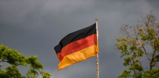 Jacke zum Public Viewing am Sonntag empfohlen Die deutsche Flagge weht vor dunklen Wolken im Wind. (Symbolbild)