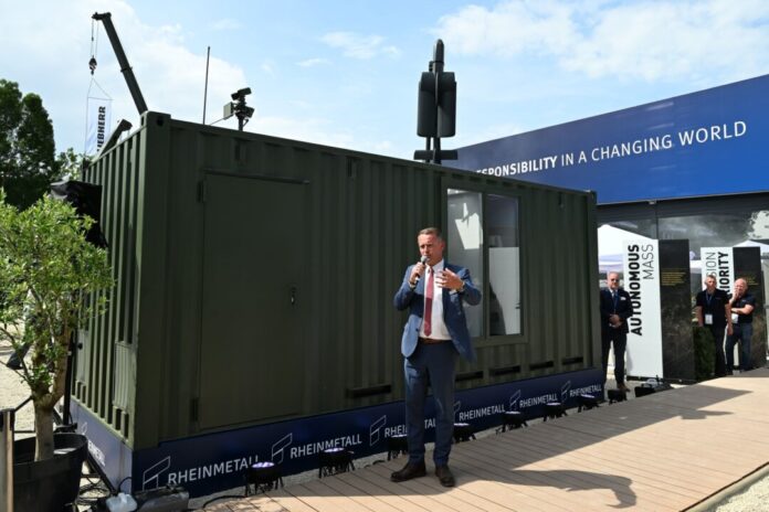 Abschuss-Container für Kamikaze-Drohnen Rheinmetall-Manager Timo Haas bewarb den Abschuss-Container bei der Rüstungsmesse Eurosatory. Auf dem Dach des Containers ist eine Kamikaze-Drohne zu sehen.