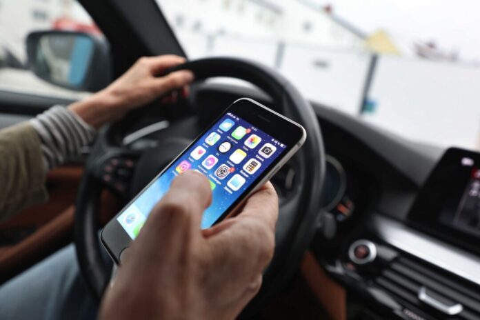 Ein Blick aufs Handy am Steuer Ein Blick auf das Handy kann sekundenlange Unaufmerksamkeit bedeuten. (Symbolbild)