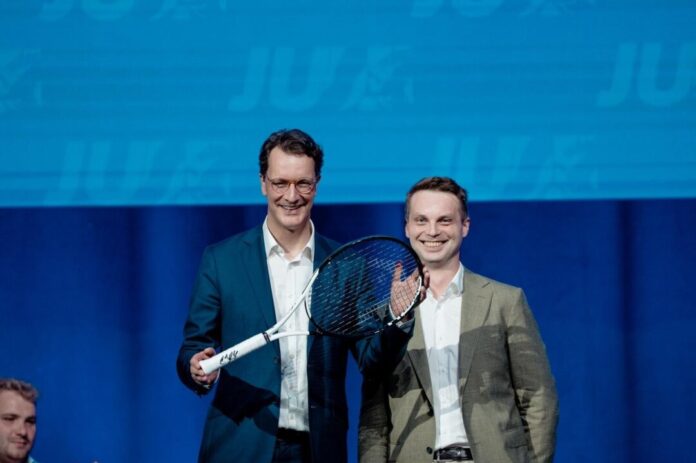 Tennisschläger als Geschenk für Hendrik Wüst Hendrik Wüst (CDU, l), Ministerpräsident von Nordrhein-Westfalen, steht mit einem Tennisschläger auf der Bühne des NRW-Tags der Jungen Union (JU) mit dem Landesvorsitzenden der JU von Nordrhein-Westfalen Kevin Gniosdorz