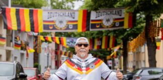 Flaggenmeer in Essen – WM-Party bei «Flaggen-Achim» «Flaggen-Achim» steht in einem Meer aus Fahnen in der Rullichstraße in Essen-Altendorf.