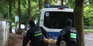Razzien nach Angriff auf Polizei bei Feier von Großfamilie Polizisten tragen einen Rammbock.