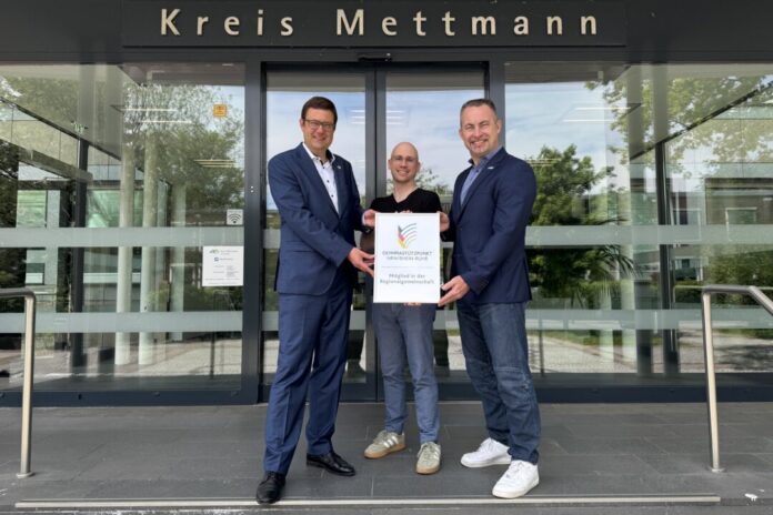 20260702_Olympiastützpunkt Kreisdirektor und Schuldezernent Philipp Gilbert, Simon Neubauer, Referent für Sport und Geschäftsführer des Ausschusses für den Schulsport, nehmen die Urkunde zur Aufnahme in die OSP-Regionalgemeinschaft Volker Lauer, Leiter Olympiastützpunkt, entgegen. Foto: Kreis ME