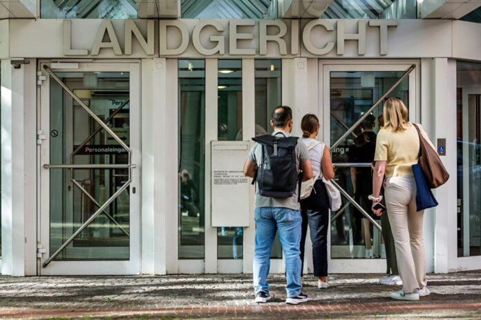 Vor Prozess am Landgericht um Verfolgungsjagd Besucher stehen vor dem Eingang des Landgerichts Münster und warten auf den Einlass. (Archivbild)