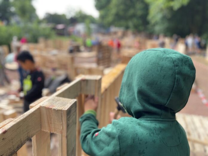 Junge auf dem Bauspielplatz Ein kurzer Regenschauer störte die Kinder beim Bau ihrer Hütte nicht beim Bau ihrer Hütte. Foto: Kreisstadt Mettmann