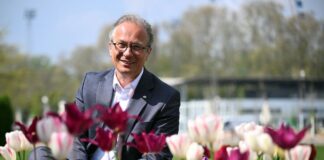 Halbzeit-Bilanz: 265.000 Besucher auf der Landesgartenschau Bürgermeister Reiner Breuer (SPD) sitzt auf dem Gelände der Landesgartenschau zwischen den Blumen.