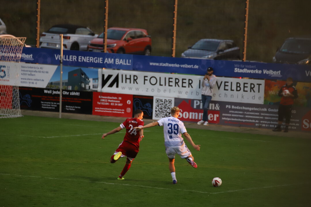 Duisburgs Peter Remmert gewinnt das Laufduell gegen Wülfraths Arman Corovic. Foto: Volkmann