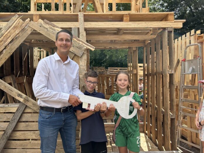 Schlüsselübergabe auf dem Bauspielplatz Bürgermeister Felix und Vizebürgermeisterin Lia übergeben den goldenen Schlüssel der "Verborgenen Siedlung" an Bürgermeister André Bär. Foto: Kreisstadt Mettmann