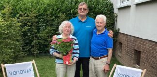Langenfeld: Ehepaar bekommt Traum vom eigenen Garten erfüllt Objektbetreuer Josef Kletsch (Mitte) begrüßt Christine und Boris Schönschitz (links und rechts) mit Hortensie und Gartenstühlen in ihrem neuen Mietergarten. Foto: Vonovia