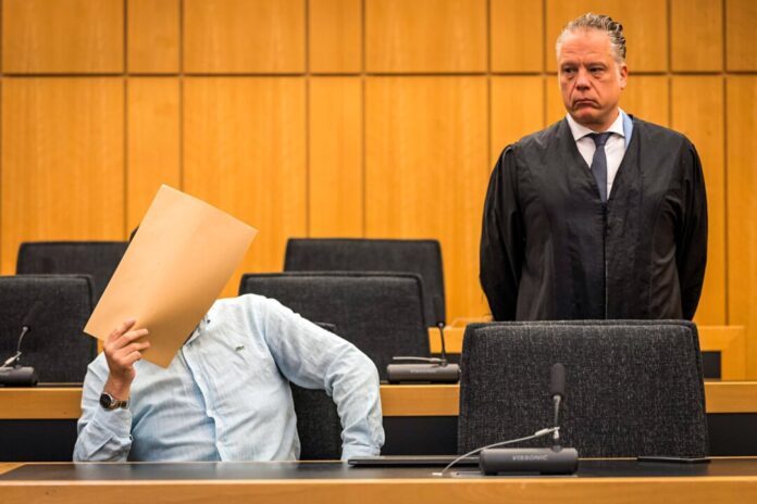 Prozess zu versuchtem Totschlag mit einem Auto als Tatwerkzeug Der Angeklagte hält sich vor Beginn des Prozesses im Saal des Landgerichts einen Umschlag vor das Gesicht.