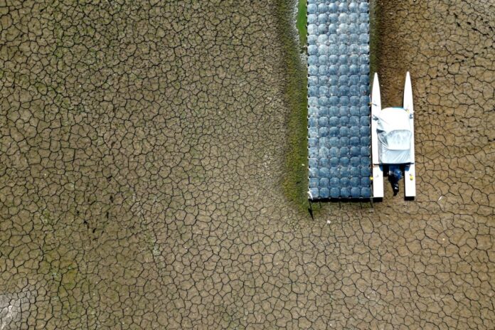 Niedrigwasser im Rhein Ein Boot liegt in einem wegen des niedrigen Wasserstands im Rhein trocken gefallenen Hafenbecken.