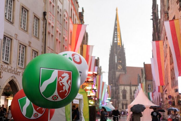 Feierlichkeiten zum 80. Landesjubiläum Nordrhein-Westfalen Ein Ballon mit dem NRW-Landeswappen schwebt im Rahmen der Feierlichkeiten zum 80. Landesjubiläum während eines Regenschauers über dem Prinzipalmarkt in Münster.