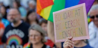 Bunte CSD-Paraden in NRW verlaufen ohne Störungen «Solidarität mit queeren Menschen» steht auf einem Plakat bei der Parade zum Christopher Street Day (CSD) in Moers.