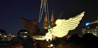 Kölner Flügelauto schwebt durch die Luft Das goldene Auto wird mit einem Kran von dem Turm gehoben.