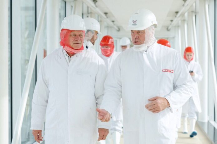 Bundeslandwirtschaftsminister Rainer besucht Schlachtbetrieb Im Schutzanzug durch einen Schlachtbetrieb: Bundeslandwirtschaftsminister Alois Rainer (l) im Gespräch mit Unternehmer Clemens Tönnies (r).