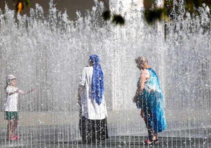 Wetter in Nordrhein-Westfalen Menschen stehen inmitten der Wasserskulptur von Jeppe Hein vor der Bundeskunsthalle in Bonn.