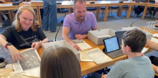 Auf den Spuren Mettmanner Unternehmer Jacqueline Muhlack aus dem Stadtarchiv und Geschichtslehrer Moritz Eschmeier sichten mit Schülerinnen und Schülern Archivmaterial. Foto: Kreisstadt Mettmann