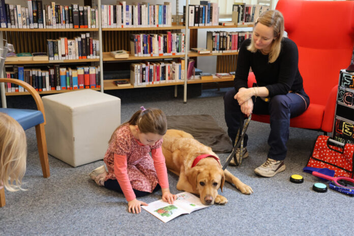 Lesehund Fido (1) Der flauschige Leselabrador Fido und Grundschullehrerin Romana Rüth sind Mitte März ein weiteres Mal zu Gast in der Bücherei Hochdahl. Foto: Stadt Erkrath