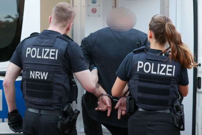 Groß angelegte Razzia gegen Geldwäscher und «Hells Angels» Ein Mann aus dem Umfeld der «Hells Angels» wird in Duisburg abgeführt.