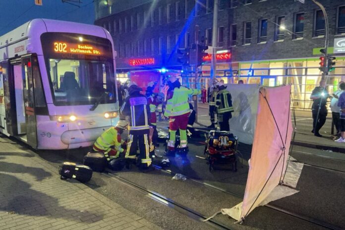Frau unter Straßenbahn eingeklemmt und schwer verletzt Rettungskräfte sind am Unfallort im Einsatz.