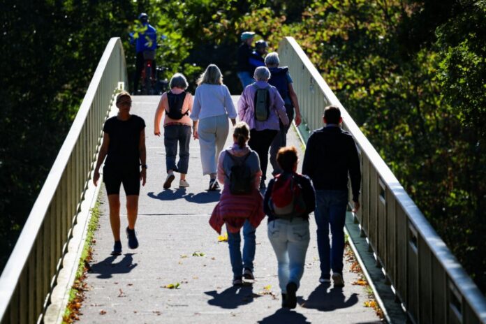 Sonnenschein in Nordrhein-Westfalen Spaziergänger laufen bei Sonnenschein über eine Brücke.