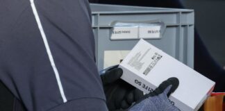 Handy-Großrazzia: Zoll scannt Tausende Geräte Beamte scannen Handys, die offenbar aus gebrauchten Teilen zusammengebaut, aber als neu verkauft wurden.
