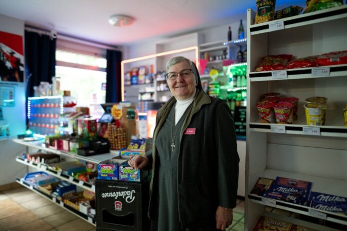 Nonne verkauft Süßes, Zigaretten und Bier an der Kiosktheke Schwester Birgit verkauft einmal pro Woche Zigaretten, Bier und Süßes in einer Bude in Gelsenkirchen.