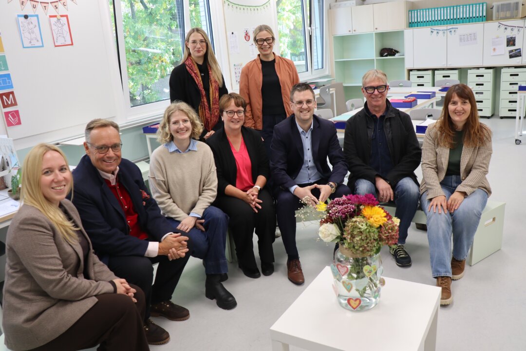 Schulleiterin Katja Leuschner, der Vorsitzende des Bezirksausschusses Hösel/Eggerscheidt und stellv. Bürgermeister Michael Droste, Jana Echterhoff (Firma Zimmermann-Haus), Schuldezernentin Sabine Klocke, Bürgermeister Patrick Anders, Stefan Welling und Adreola Jaupi (beide Stabsstelle für besondere Hochbaumaßnahmen) sowie (stehend von links) die beiden Innenarchitektinnen Sophie Jenske und Barbara Eitner. Foto: Stadt Ratingen
