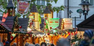 Glühwein im Oktober: Früh-Weihnachtsmarkt in Essen eröffnet Besucher gehen an beleuchteten Verkaufshütten vorbei.