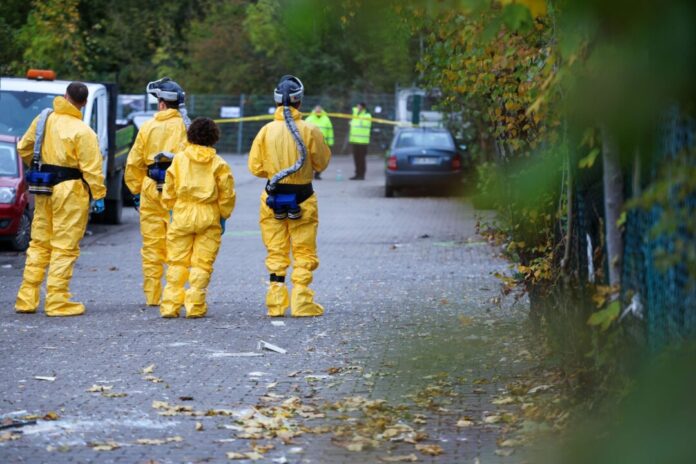 Ermittlungen nach Explosion in Bochumer Lagerhalle dauern an Nach einer Explosion in Bochum mussten Einsatzkräfte Schutzausrüstung tragen.